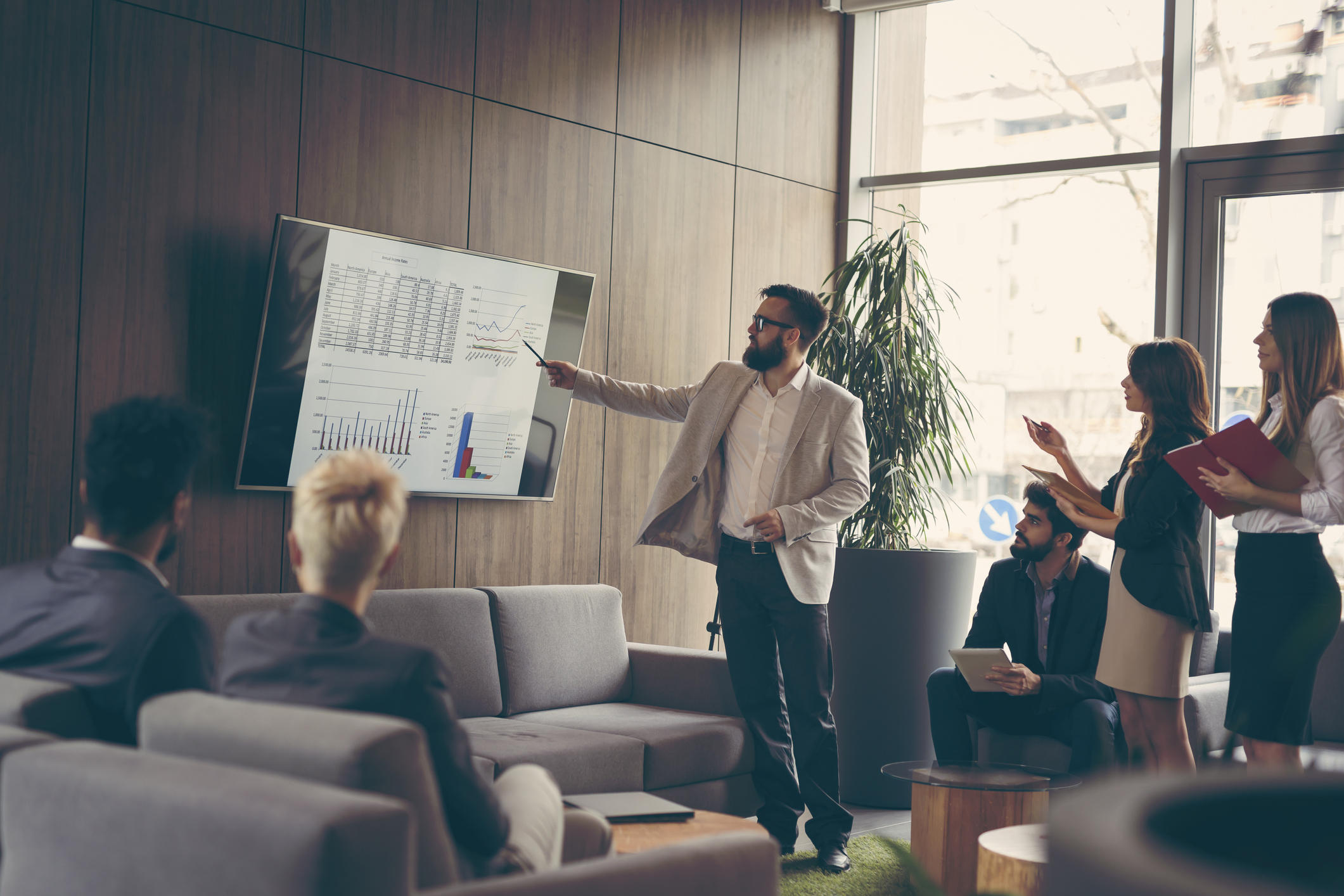 Business man pointing to dashboards on a large screen